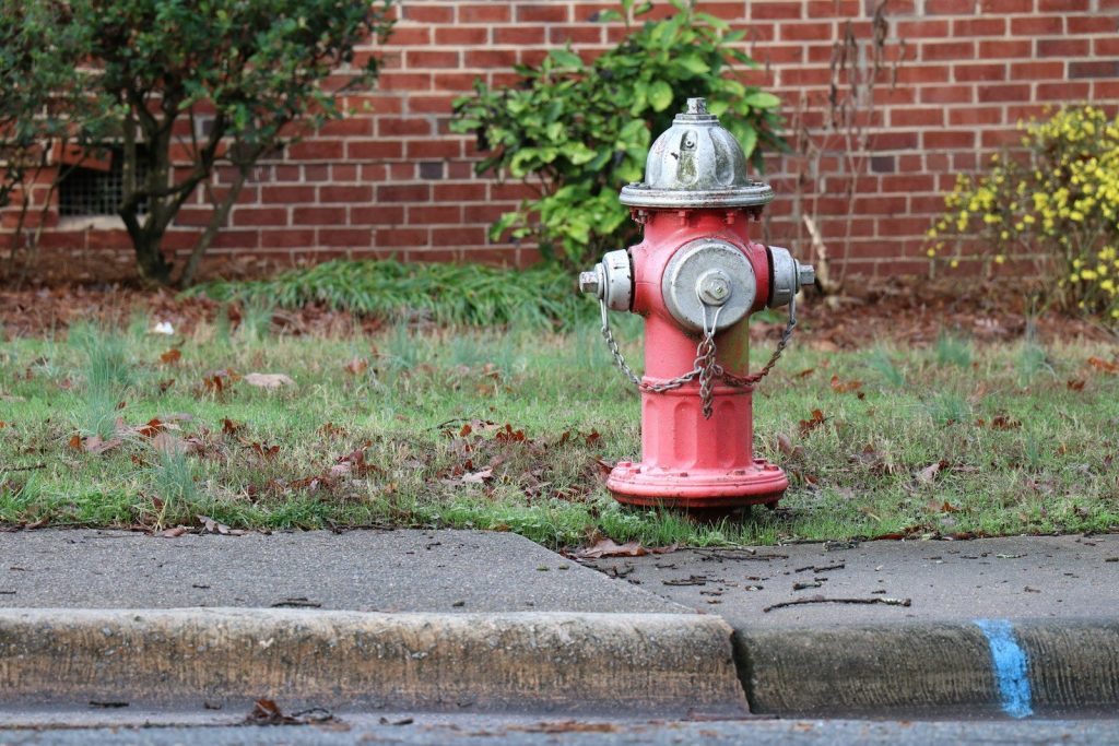 red and gray fire hydrant beside sidewalk