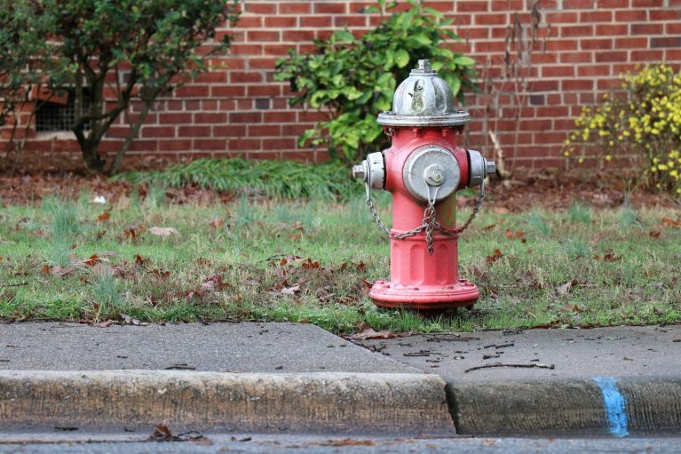 red and gray fire hydrant beside sidewalk