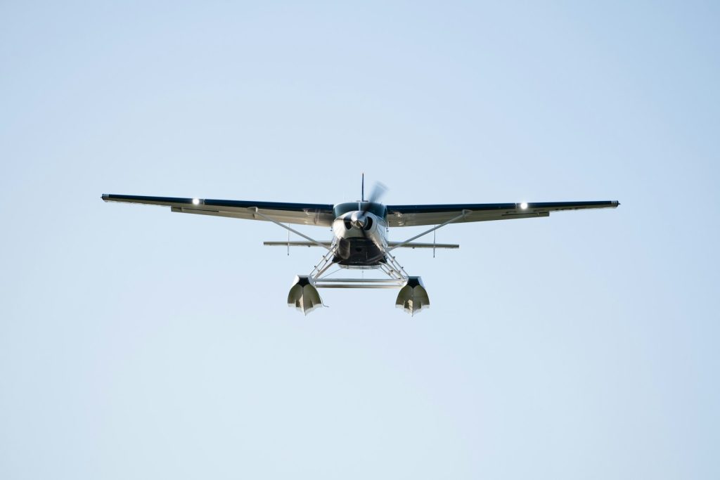 a small propeller plane flying through a blue sky
