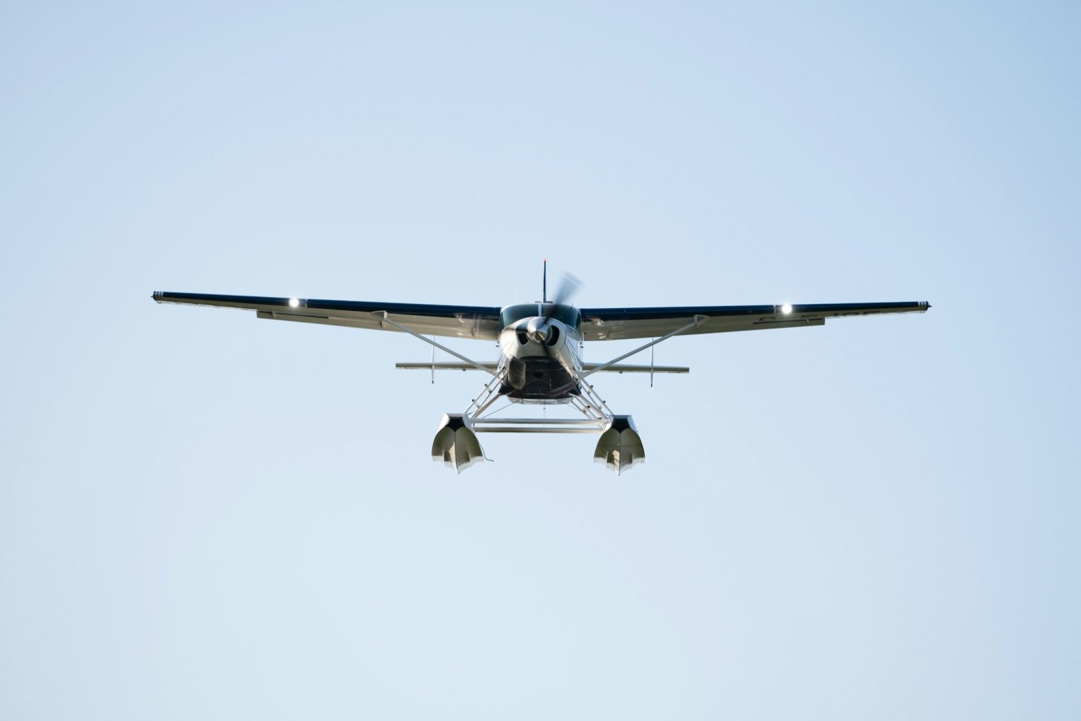 a small propeller plane flying through a blue sky
