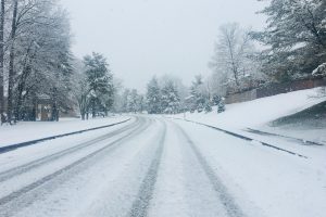 Photo by Amit Godase snow covered road between trees during daytime