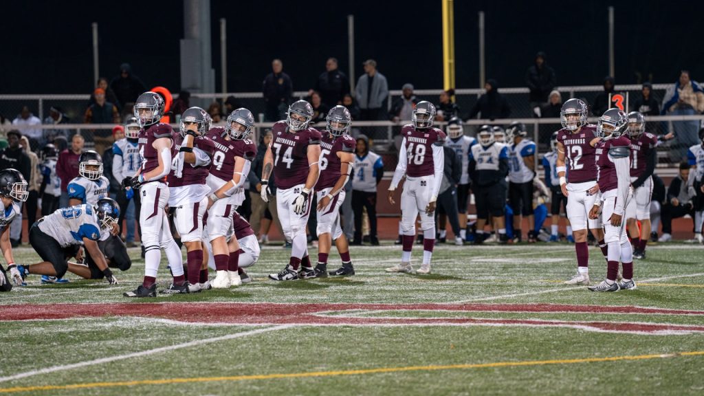 A group of football players standing on top of a field